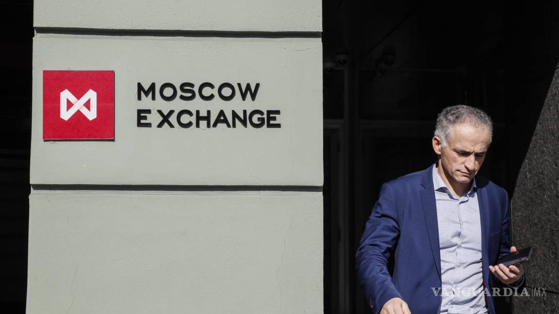 $!Un hombre camina cerca de un edificio con un tablero con el logo de la Bolsa de Moscú en el centro de Moscú, Rusia.