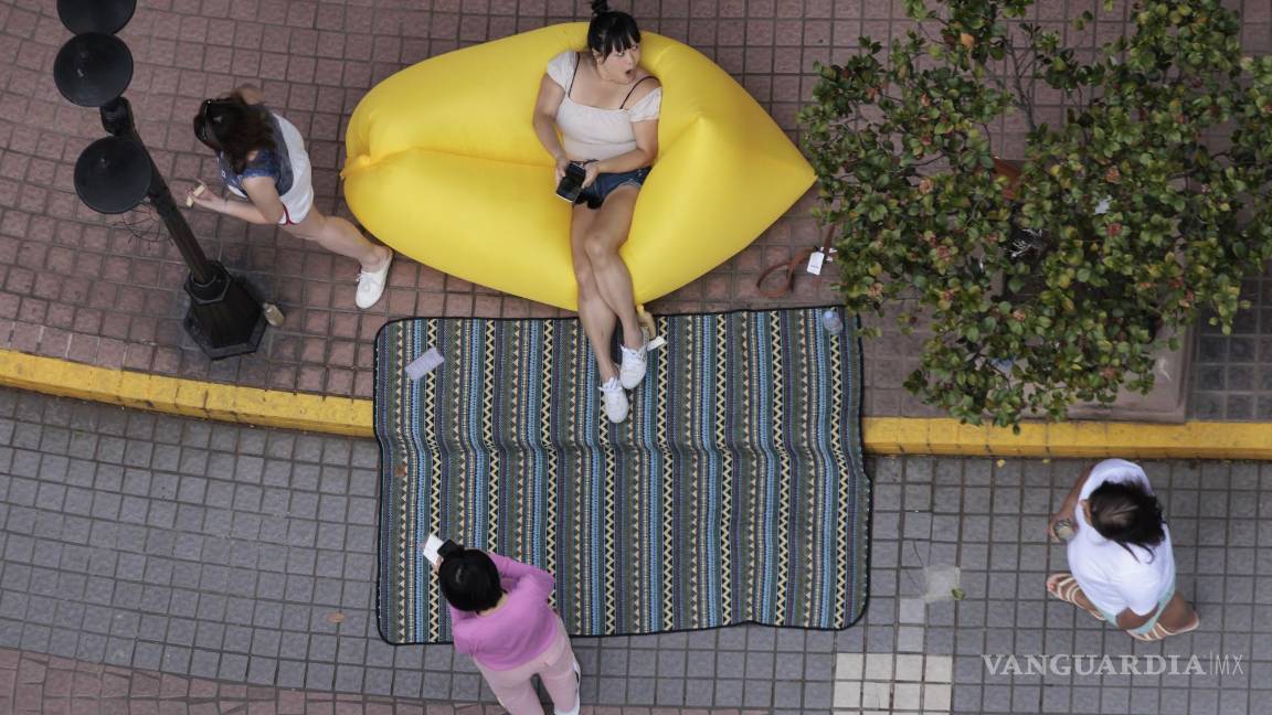 $!Las personas en cuarentena se reúnen fuera de su complejo residencial en Shanghái, China.