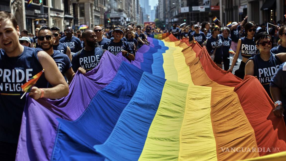 $!Unas personas con una bandera LGBTQ a lo largo de la Quinta Avenida durante el Desfile del Orgullo Gay de la ciudad de Nueva York.