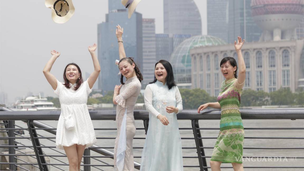 $!Las mujeres lanzan sus sombreros al aire para celebrar el alivio de las restricciones de COVID-19, en Shanghái, China.