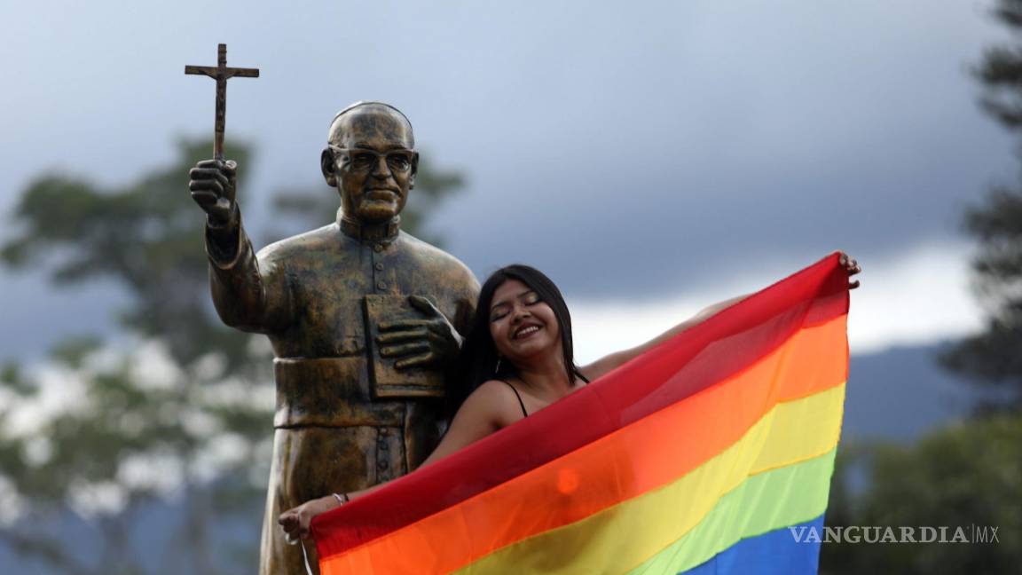 $!Una integrante de la comunidad LGBTI+ junto a una estatua de San Óscar Romero, durante la Marcha del Orgullo en San Salvador, El Salvador.