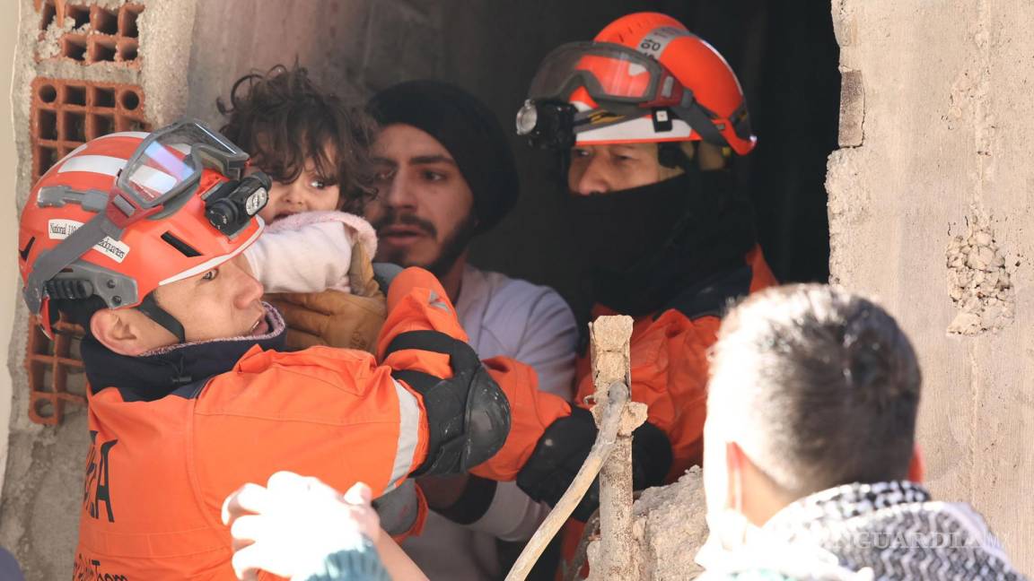 $!Miembros del equipo de rescate de emergencias surcoreano rescatan a una niña entre los escombros en Antioquía, Turquía.