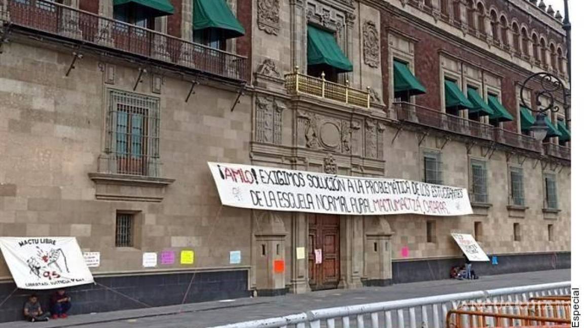 Normalistas de Chiapas saltan vallas de Palacio Nacional y colocan manta