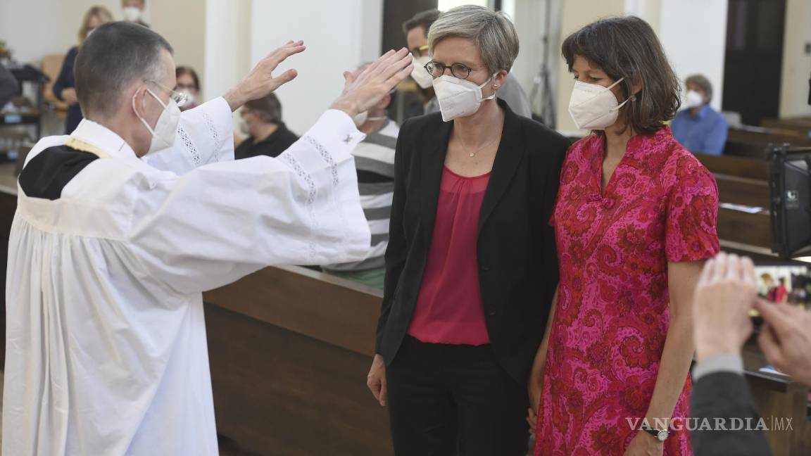 $!El vicario Wolfgang Rothe bendice a la pareja de Christine Walter, centro, y Almut Muenster, en un oficio católico de bendición de parejas del mismo sexo en Munich.