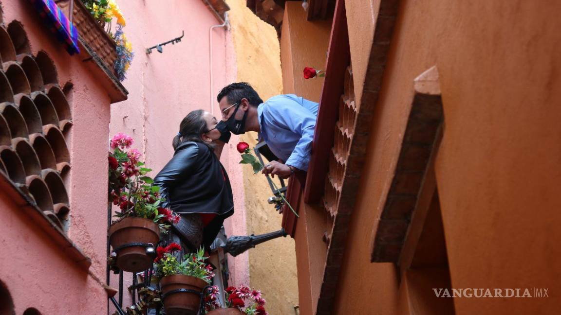 $!Dos jovenes se besan con un cubrebocas en el famoso y tradicional callejon del beso en Guanajuato.