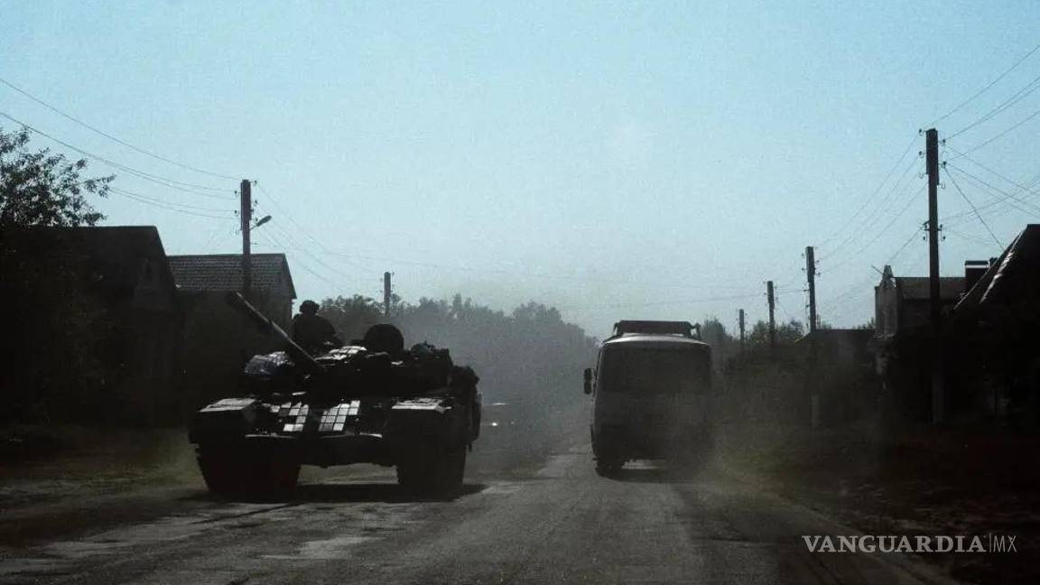 $!Un autobús civil circulaba el pasado mes de agosto junto a un tanque ucraniano a 9 kilómetros de la frontera con Rusia, en la región ucraniana de Sumi.