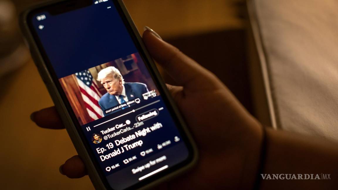 $!Un espectador mira la entrevista de Donald Trump por parte de Tucker Carlson en la plataforma ‘X’ de su teléfono en Miami, Florida.