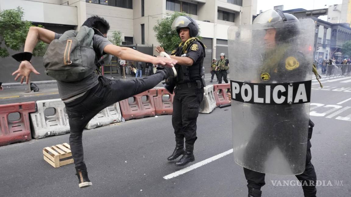 $!Un partidario del derrocado presidente Pedro Castillo patea a un oficial de policía durante una protesta en Lima, Perú.