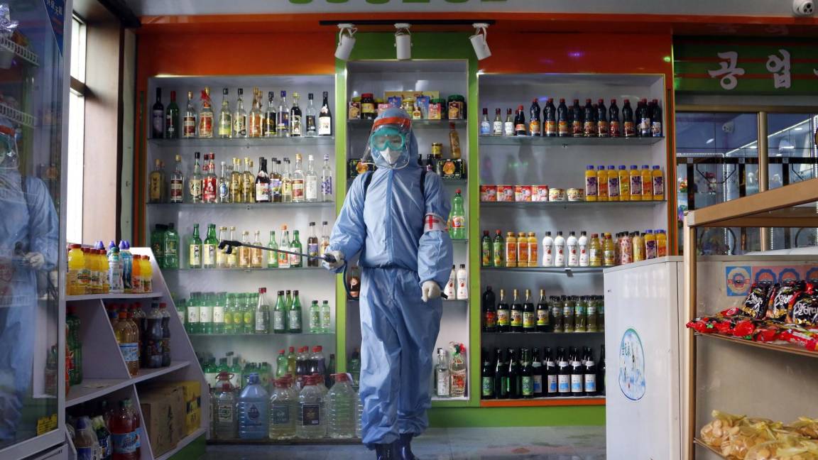 $!Un empleado de Kyonghung Foodstuff General Store desinfecta la sala de exposición en Pyongyang, Corea del Norte.