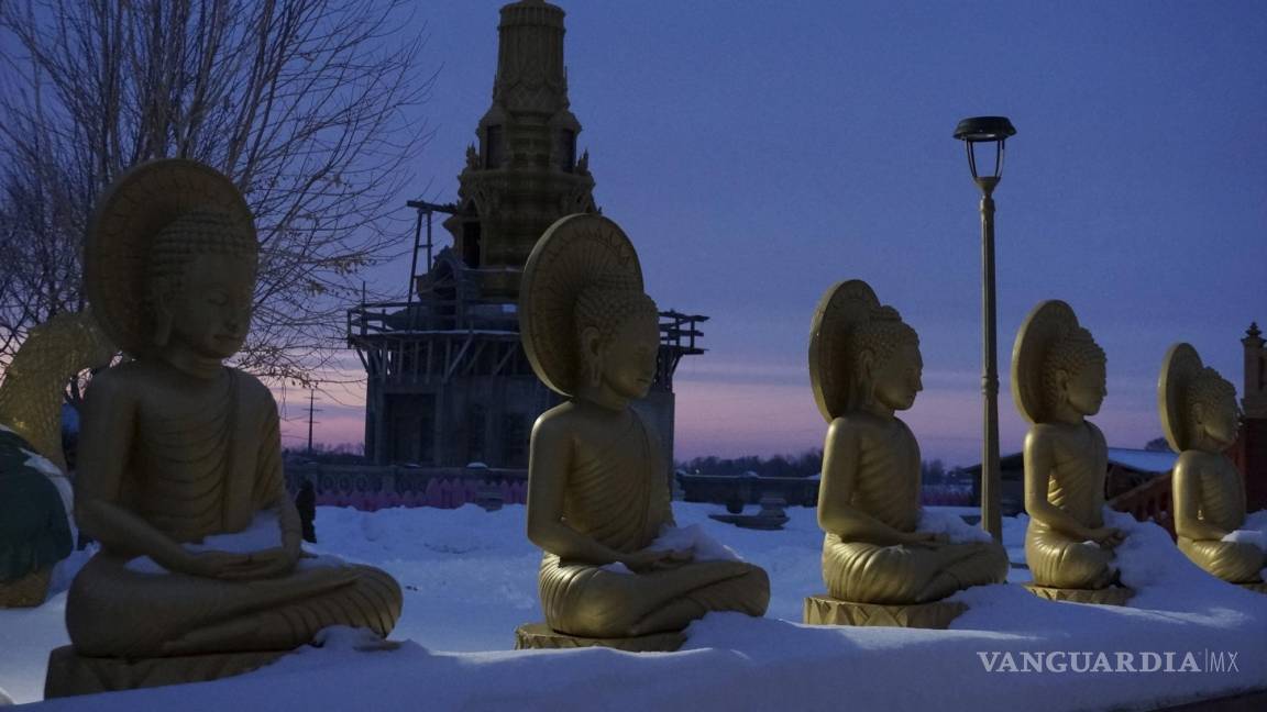 $!Estatuas de Buda y la estupa que alberga sus reliquias al anochecer en el complejo del templo Watt Munisotaram el sábado 4 de febrero de 2023 en Hampton, Minnesota.