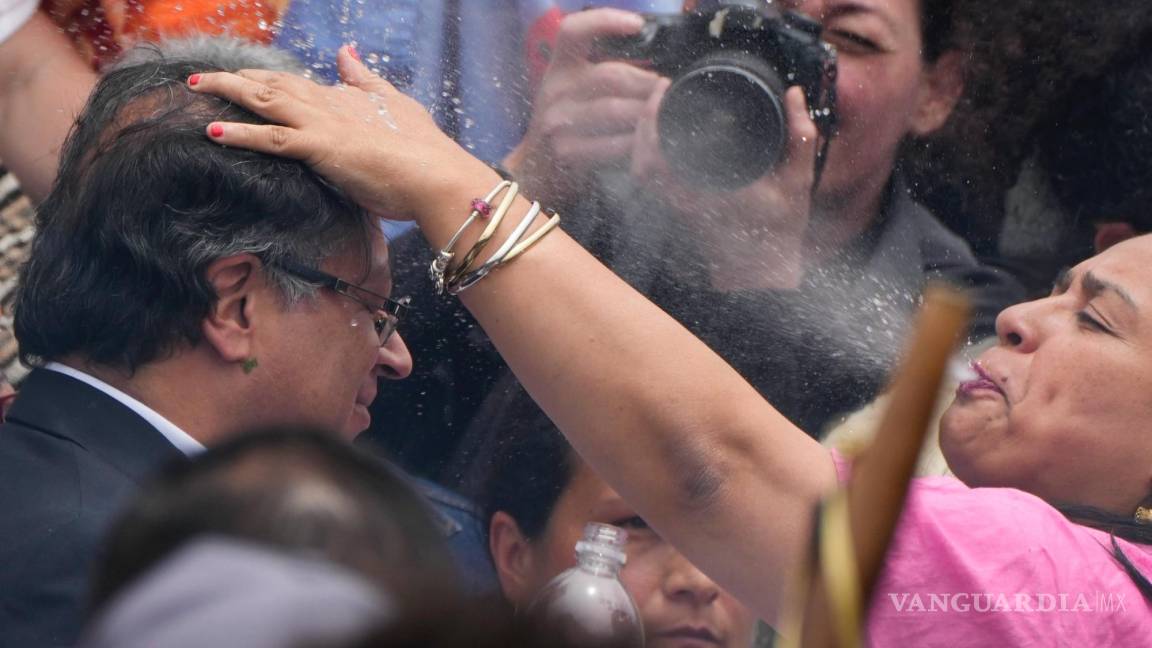 $!Una mujer indígena escupe agua sobre la cabeza del presidente electo Gustavo Petro, durante una ceremonia de toma de posesión “popular y espiritual”.