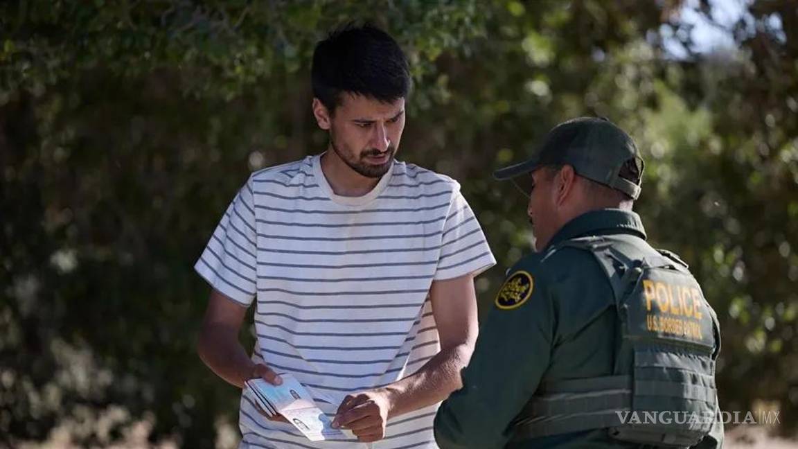 $!Un migrante dialoga con la Patrulla Fronteriza de Estados Unidos en la frontera entre EU y México en Jacumba, California.