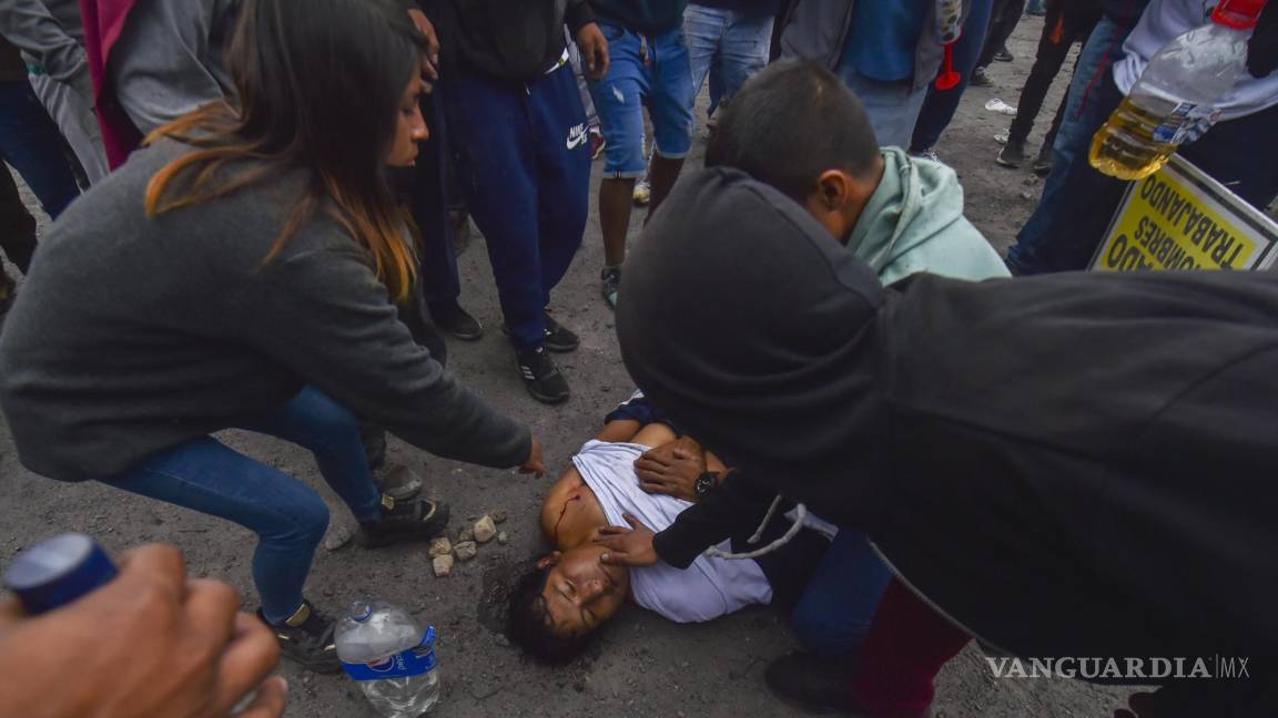 $!Personas ayudan a un hombre herido en las protestas contra el gobierno en Arequipa, Perú.