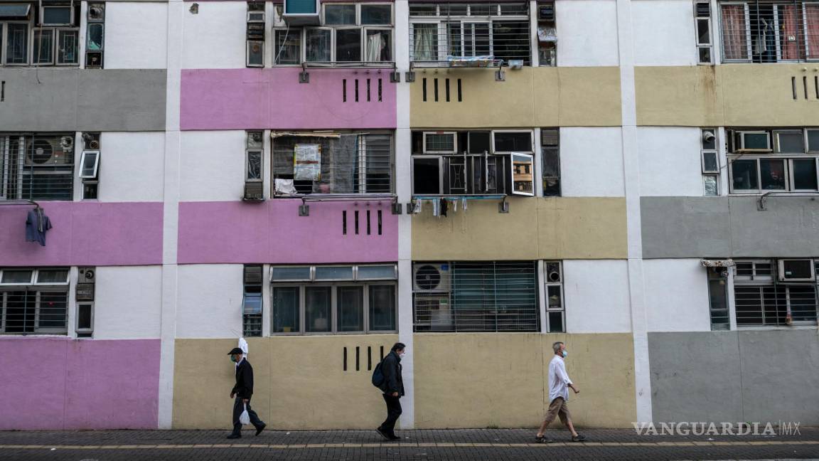 $!La gente pasa frente a edificios de viviendas públicas en Hong Kong.