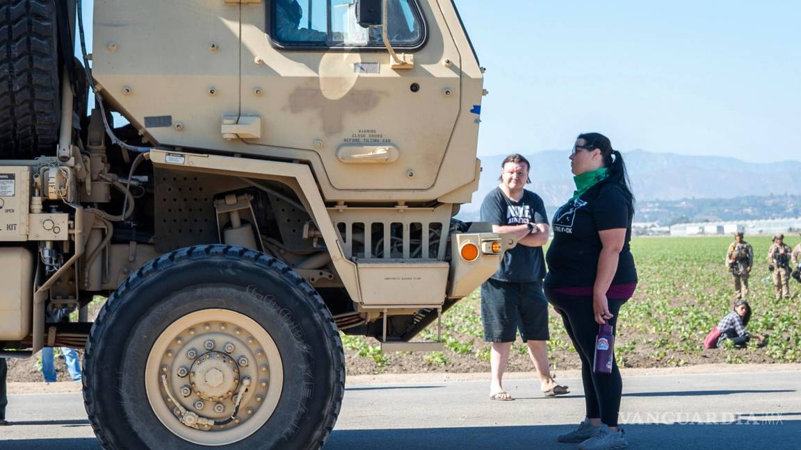 $!Rebecca Torres se encuentra frente a un vehículo militar que se acerca a una redada de agentes federales de inmigración en el área agrícola de Camarillo.