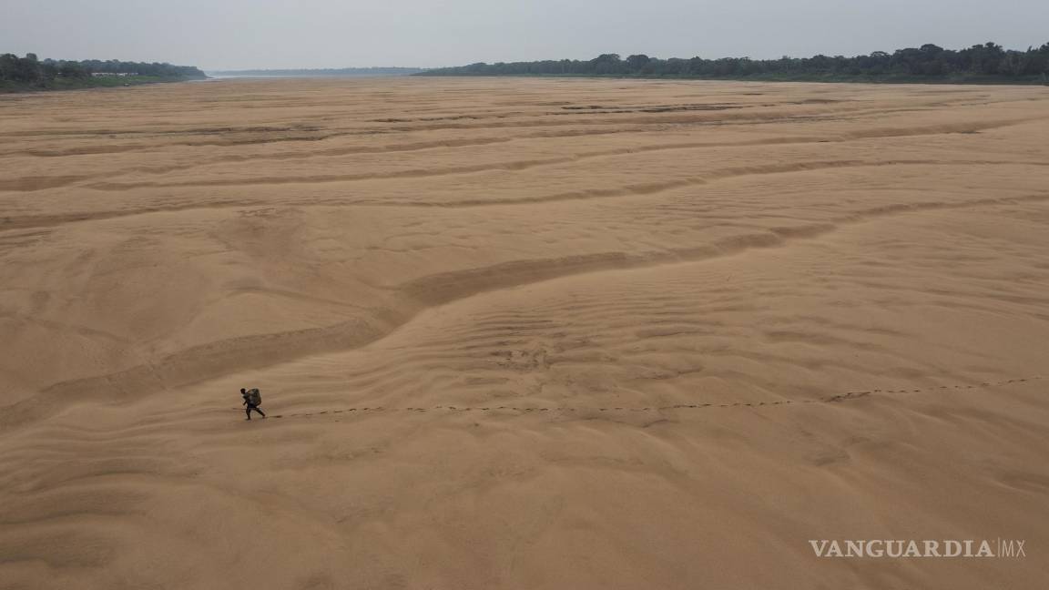 $!Imagen de Lalo de Almeida para Folha de Sao Paulo de un pescador caminando por el lecho seco de un brazo del río Amazonas en Brasil, 13 de octubre de 2023.