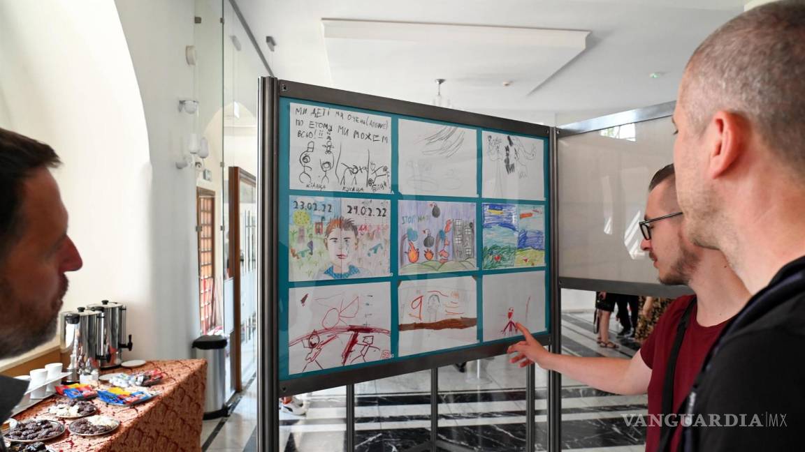 $!Personas miran los dibujos hechos por niños ucranianos en la exposición titulada ‘Guerra dibujada con un crayón’.