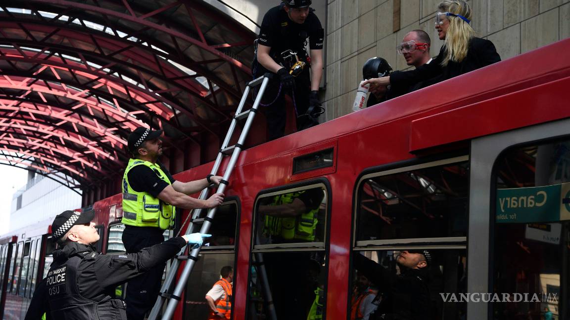 $!Activistas contra el cambio climático se “pegan” con pegamento al techo de a un tren en Londres