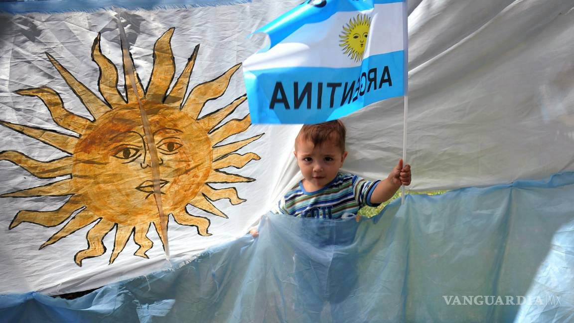 $!Un niño posa con banderas de Argentina durante la celebración de su triunfo de la selección argentina en el Mundial de Qatar 2022 en una calle de Buenos Aires.