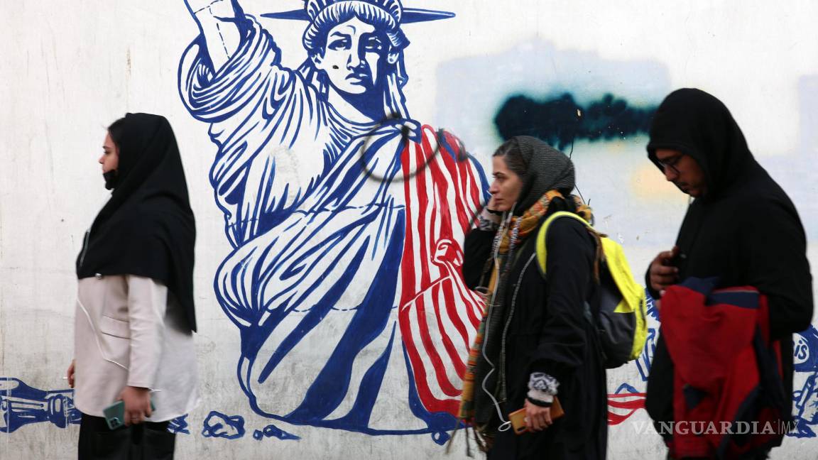 $!Tres mujeres pasan ante un grafiti antiestadounidense junto a la antigua embajada de Estados Unidos en Teherán.