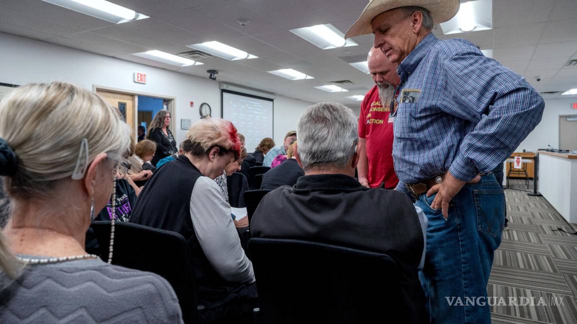 $!Curt Miller, a la derecha, pastor de la Iglesia East Mountain Cowboy, ora con los asistentes a la reunión del Concejo Municipal, en Edgewood, Nuevo México.
