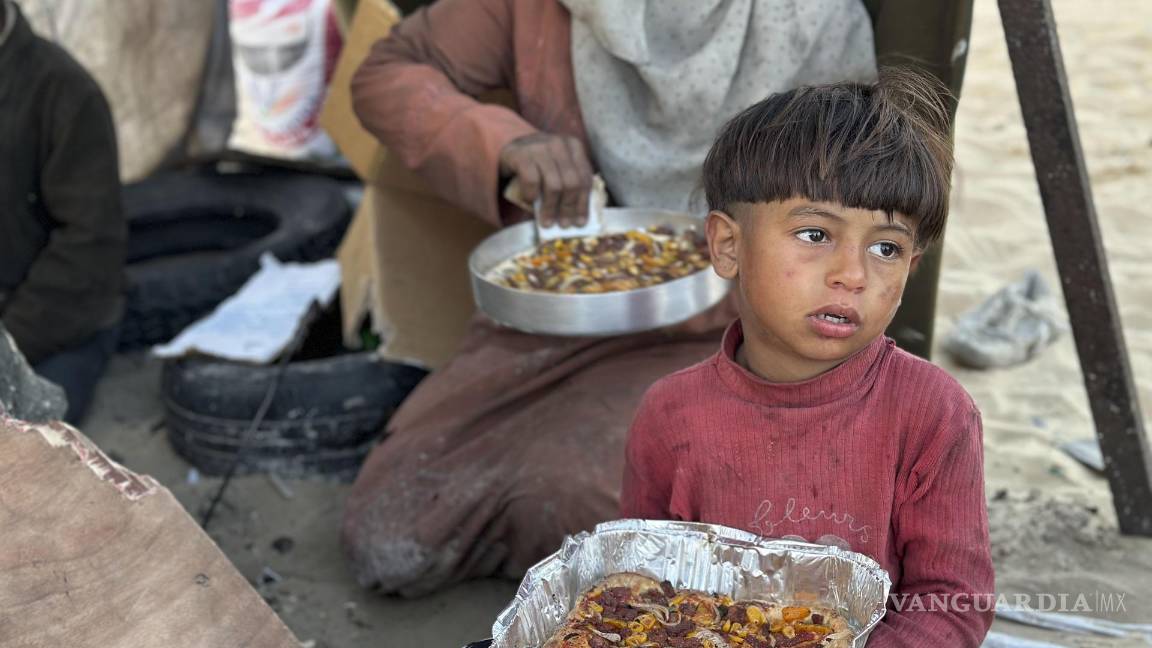 $!Un niño come un plato del Iftar, que marca la ruptura del ayuno en ramadán en Rafah, Gaza.