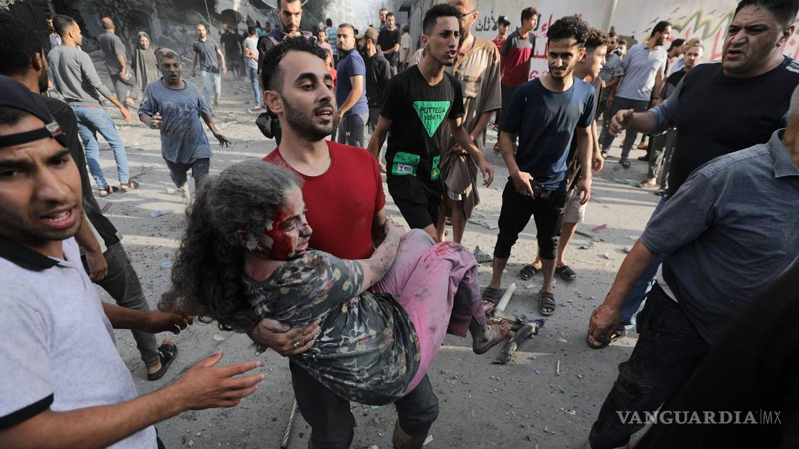 $!Un hombre lleva a una niña herida tras los ataques aéreos israelíes en el norte de Gaza.