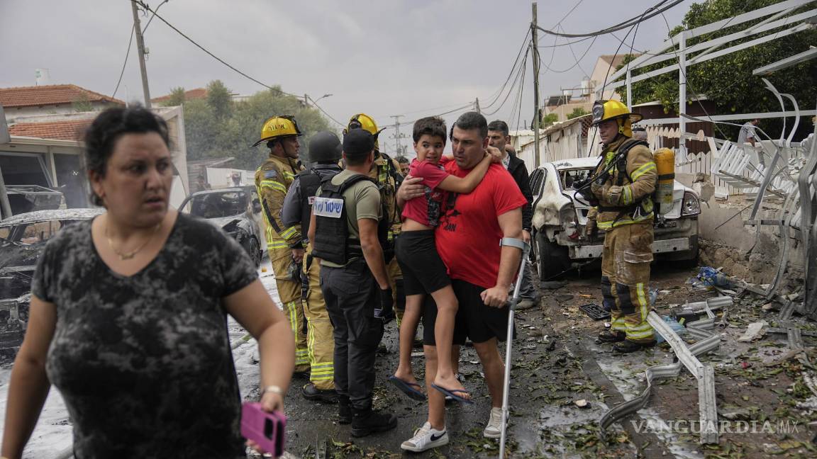 $!Israelíes evacuan una zona alcanzada por un proyectil disparado desde la Franja de Gaza, en Ashkelon, en el sur de Israel, el 9 de octubre de 2023.