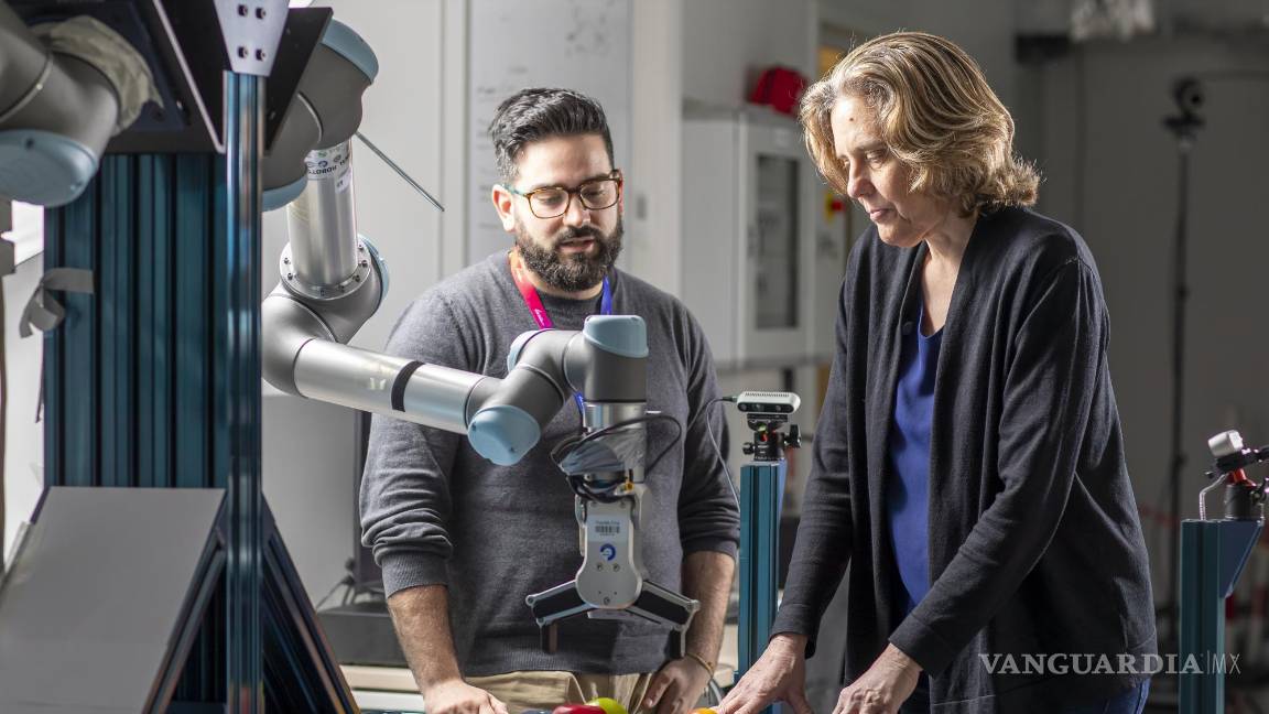 $!Cordelia Schmid y un investigador observando un brazo robótico.