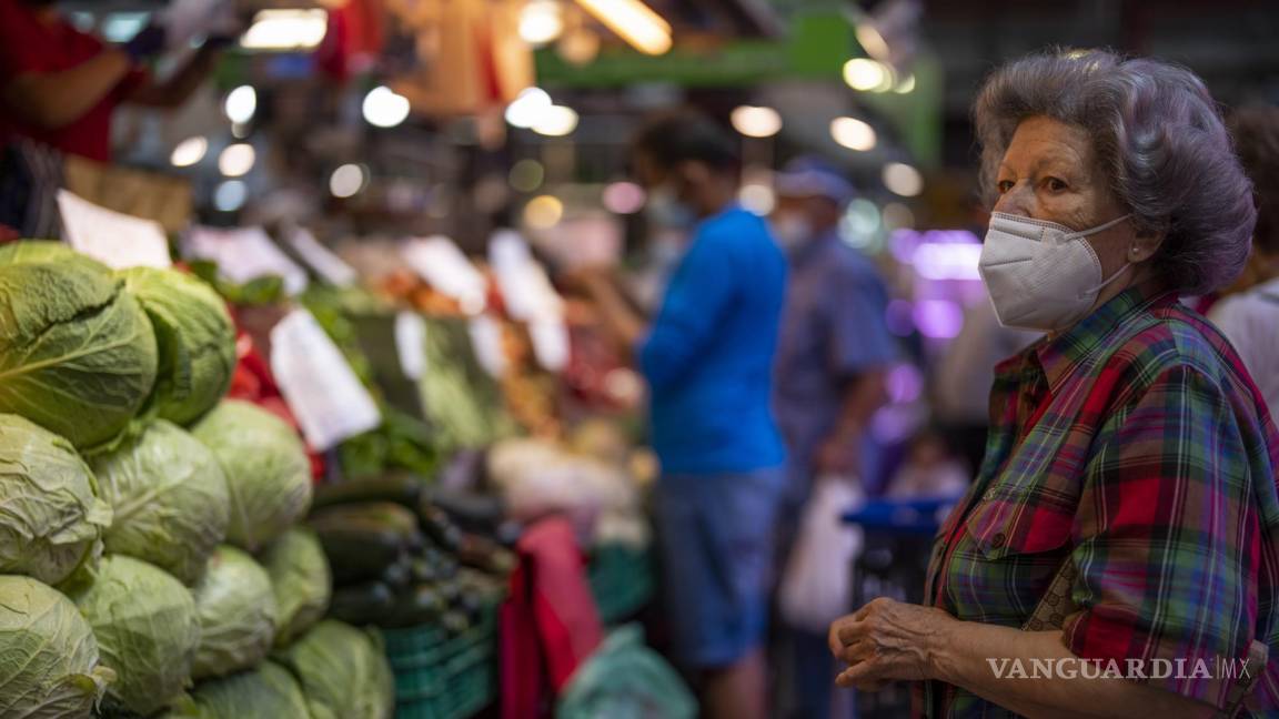 $!Un cliente con mascarilla espera para comprar verduras en el mercado de Maravillas en Madrid, España.