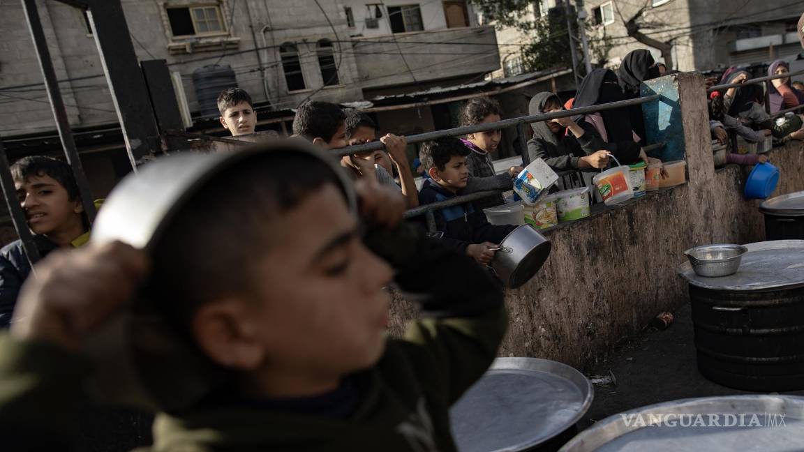 $!Palestinos desplazados se reúnen para recoger alimentos donados por un grupo benéfico antes del desayuno, el cuarto día del mes sagrado del Ramadán en Rafah.