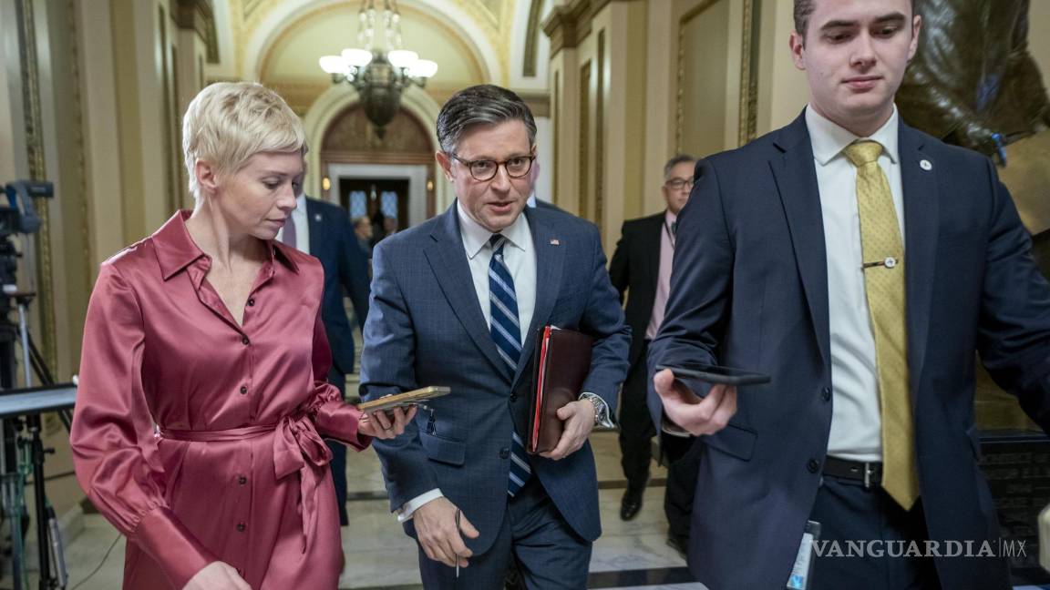 $!El presidente de la Cámara de Representantes, Mike Johnson (c), responde a una pregunta de los medios de comunicación mientras camina hacia su oficina.
