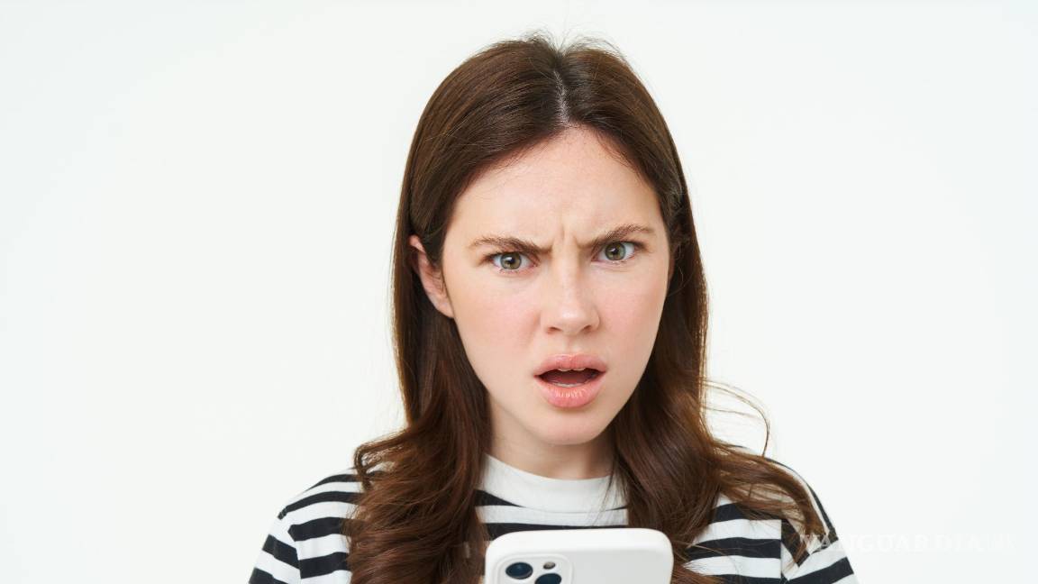 $!Joven alarmada tras mirar su teléfono móvil.