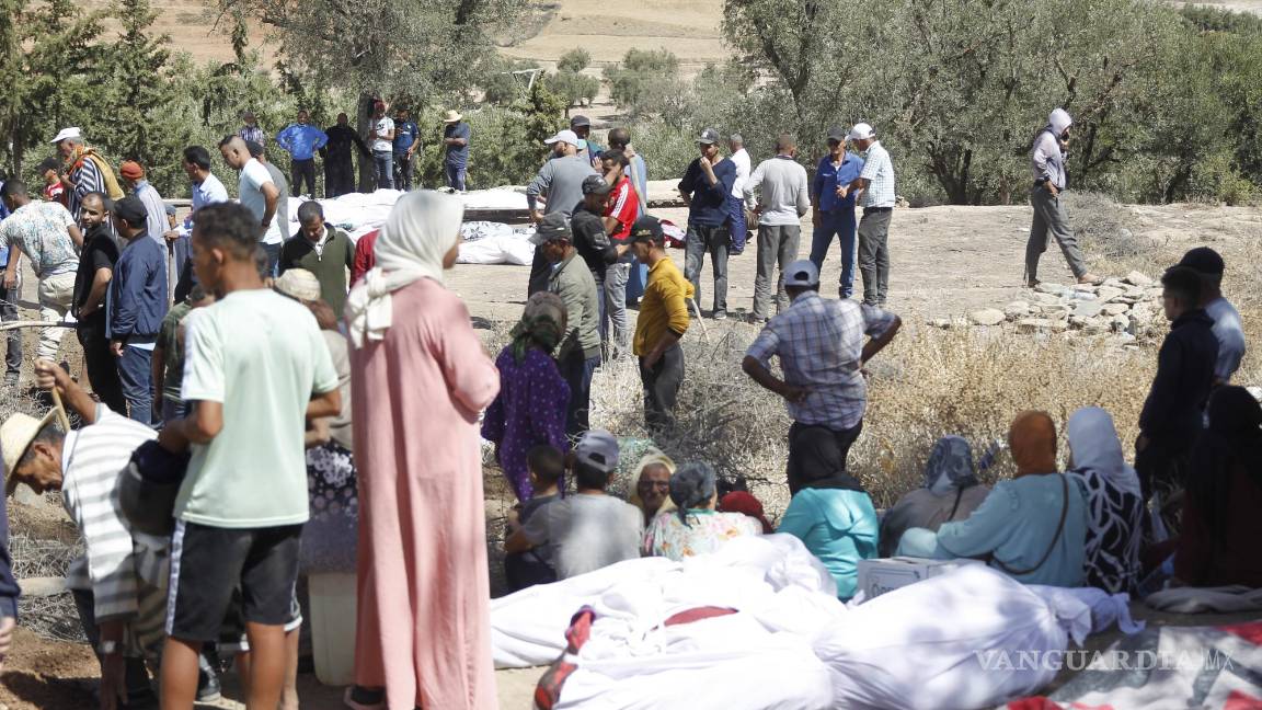 $!Varias personas entierran a sus fallecidos en la aldea][de Tafagajt, en Marruecos, cerca del epicentro del devastador terremoto.