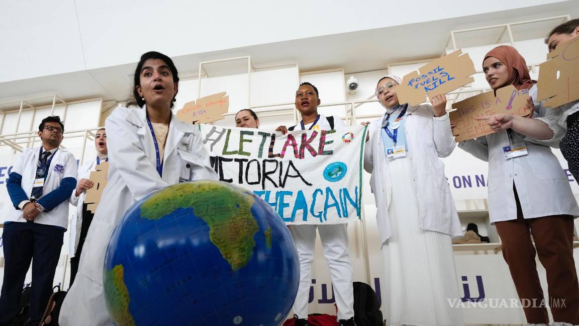 $!Una mujer simula reanimar al planeta Tierra durante una manifestación en la conferencia climática COP28 en Dubái, Emiratos Árabes Unidos.