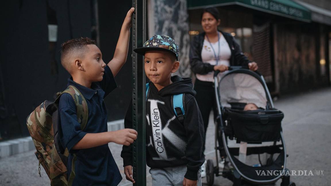 $!La inmigrante ecuatoriana Kimberly Carchipulla, derecha, y su hijo Damien, al centro, aguardan el autobús en su camino a la escuela en Nueva York.