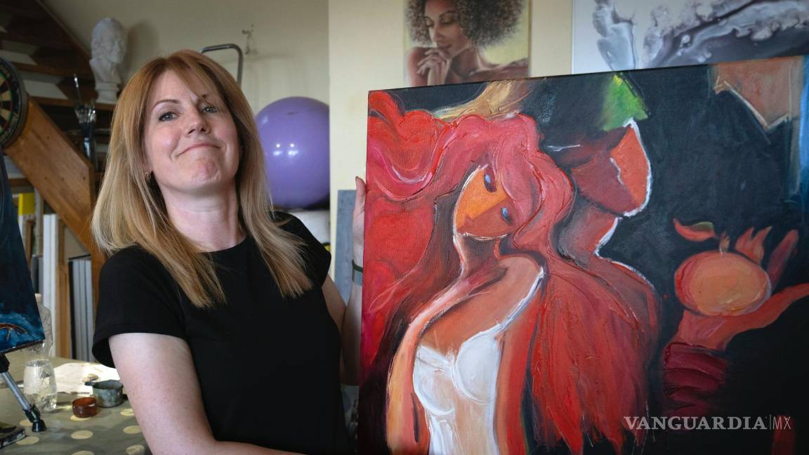 $!Vita Kahaniuk sostiene su pintura que creó para conmemorar a su esposo, un soldado que murió en una batalla con las tropas rusas en Kiev.