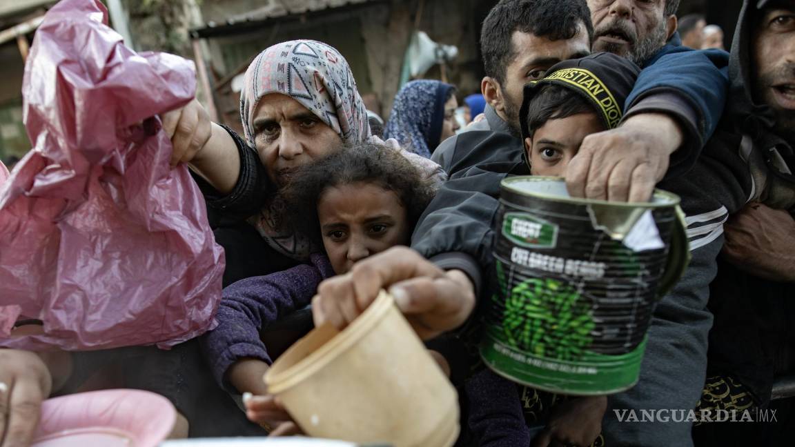$!Palestinos desplazados se reúnen para recoger alimentos donados por un grupo benéfico antes del desayuno, el cuarto día del mes sagrado del Ramadán en Rafah.