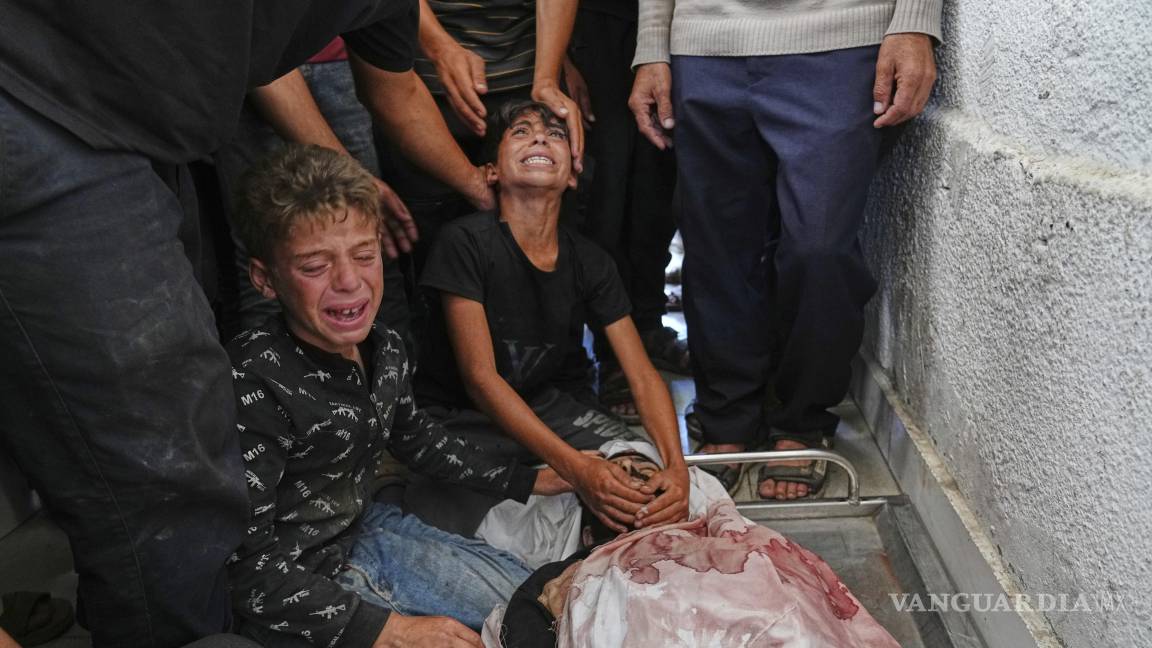 $!Niños palestinos lloran el cuerpo de su padre, Mohammed Ghaben, quien murió mientras se dirigía a un centro de distribución de ayuda humanitaria.