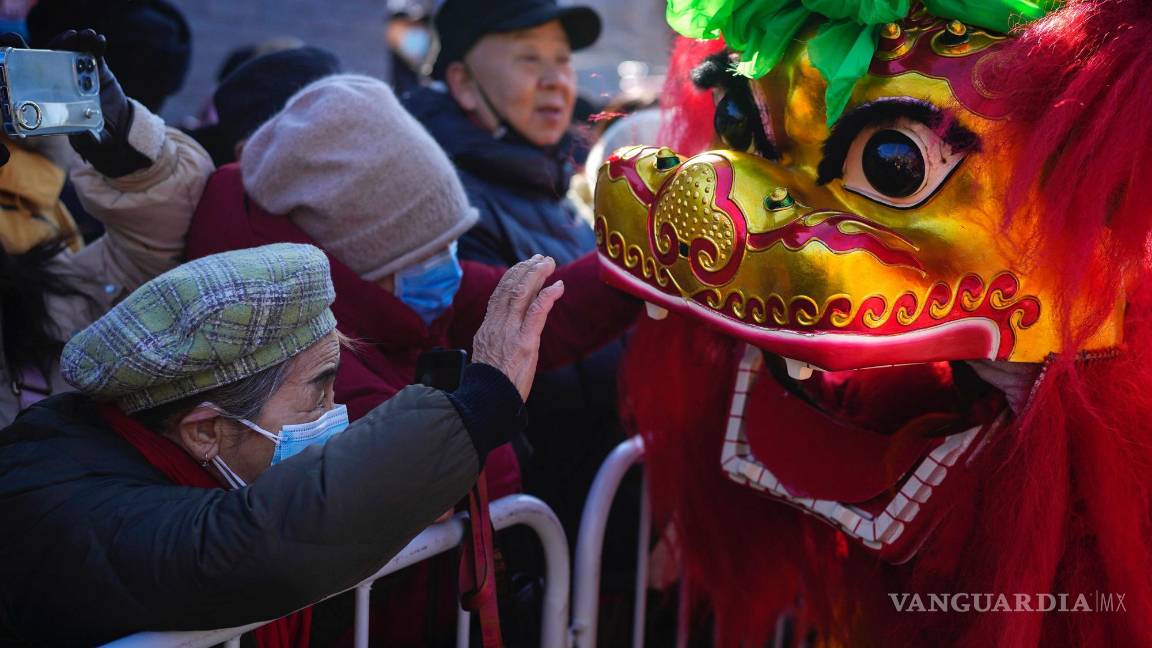 $!Una mujer toca un león danzante mientras los residentes asisten a un festival en el templo de Dongyue, en el primer día del Año Nuevo Lunar, en Beijing.