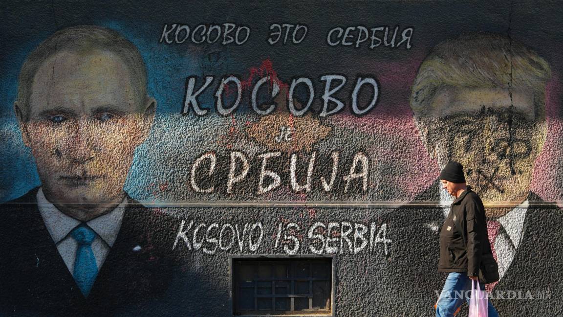 $!Un hombre pasa junto a un grafiti que dice “Kosovo es Serbia” y que muestra a Vladimir Putin y a Donald Trump, vandalizados con pintura, en Belgrado, Serbia.