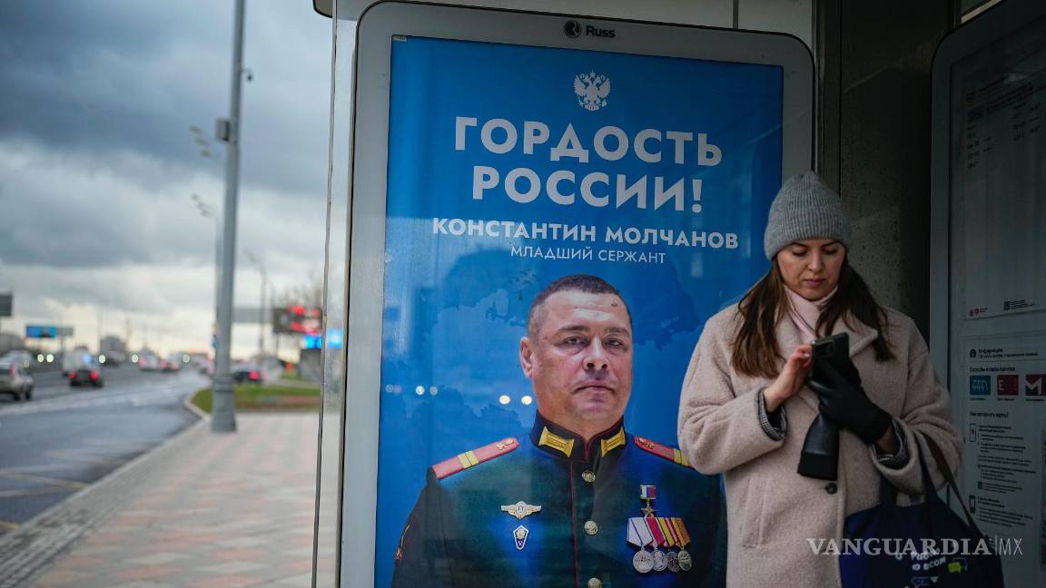$!Una mujer en una parada de autobúscon un cartel que dice “Orgullo de Rusia” que muestra a un soldado ruso de la operación militar en Ucrania, en Moscú, Rusia.