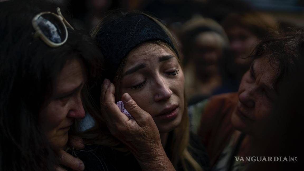 $!Anastasia Ohrimenko es consolada por sus familiares mientras llora junto al féretro de su esposo durante su funeal, en Bucha, Ucrania, el 31 de agosto de 2022.