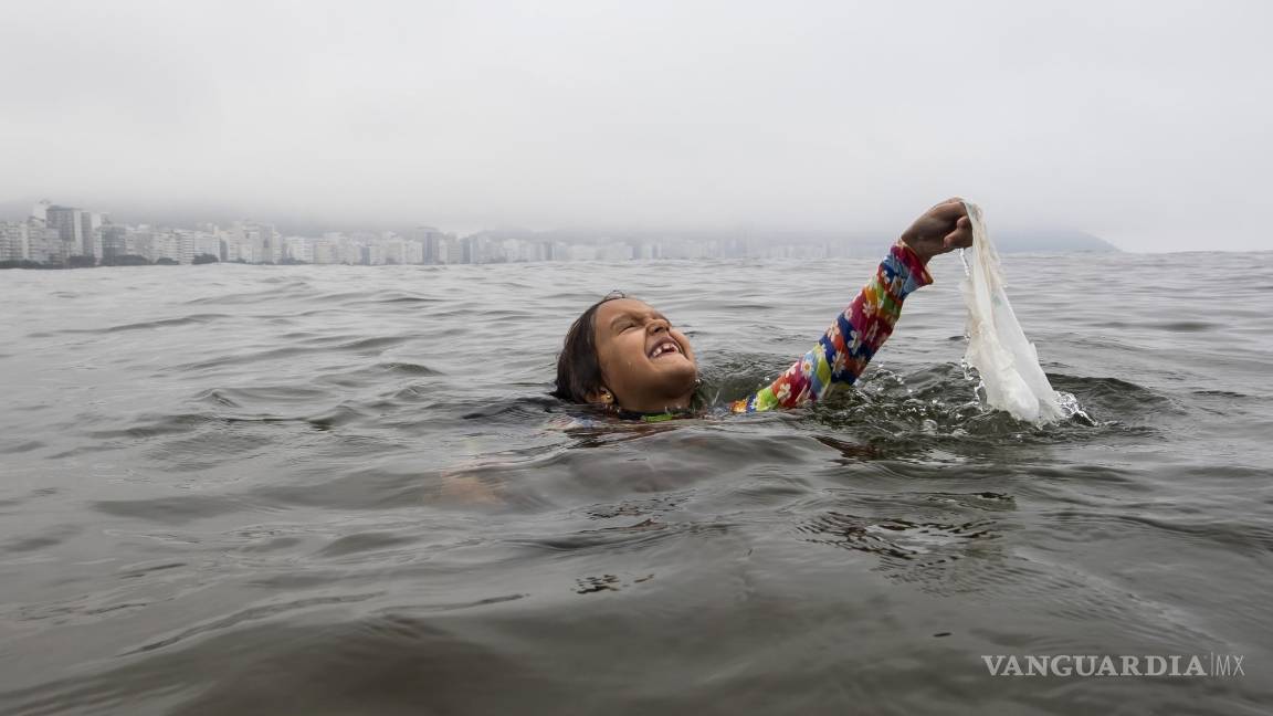 $!Nina Gomes recupera una bolsa de plástico desechada de las aguas del océano, cerca de la playa de Copacabana en Río de Janeiro, Brasil.