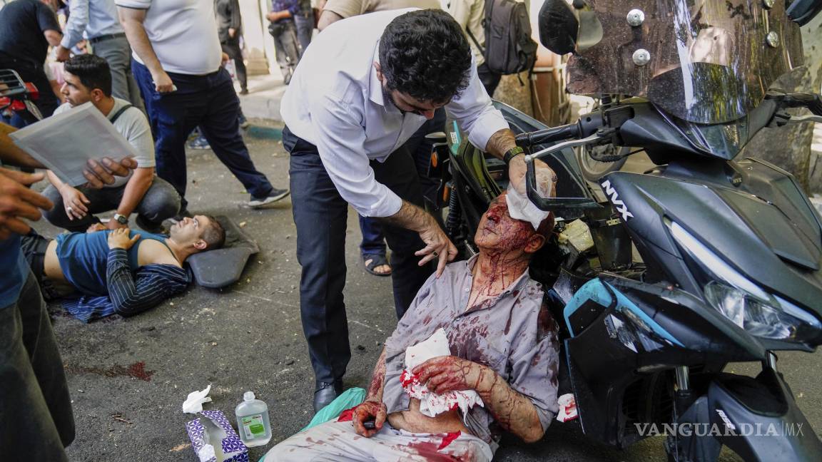 $!Un hombre herido recibe ayuda en la calle tras una explosión en el centro de Teherán, en medio de la campaña de tres días de ataques de Israel contra Irán.