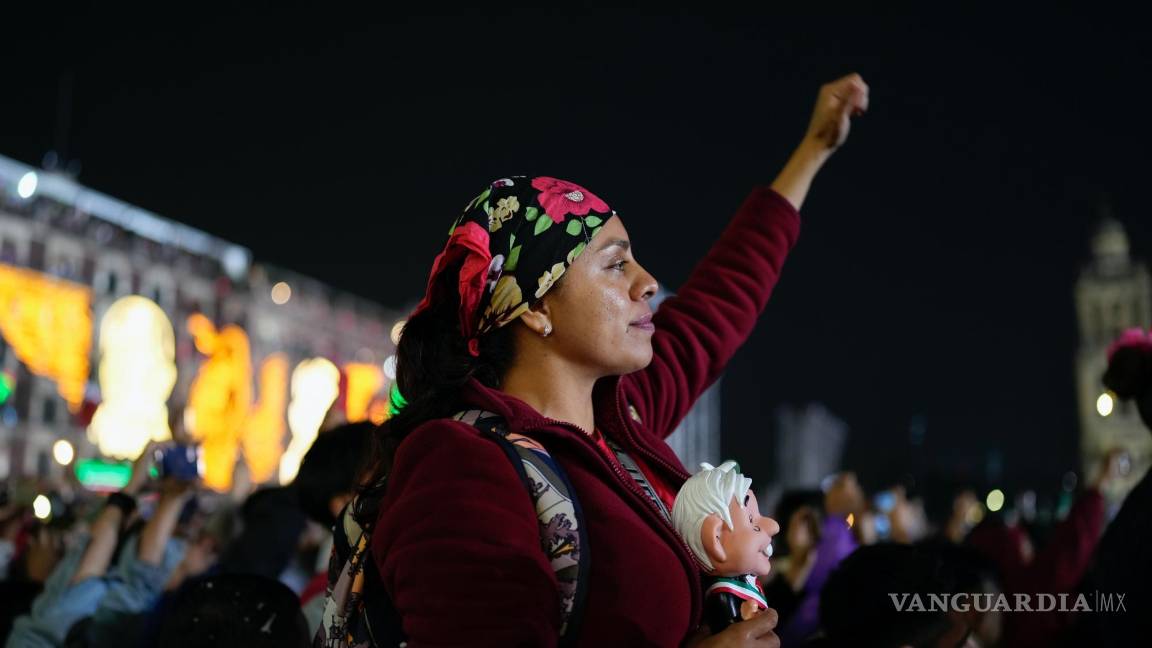 $!Una partidaria de AMLO sostiene un muñeco con su imagen mientras lo escucha dar el grito anual del Día de la Independencia desde el balcón del Palacio Nacional.