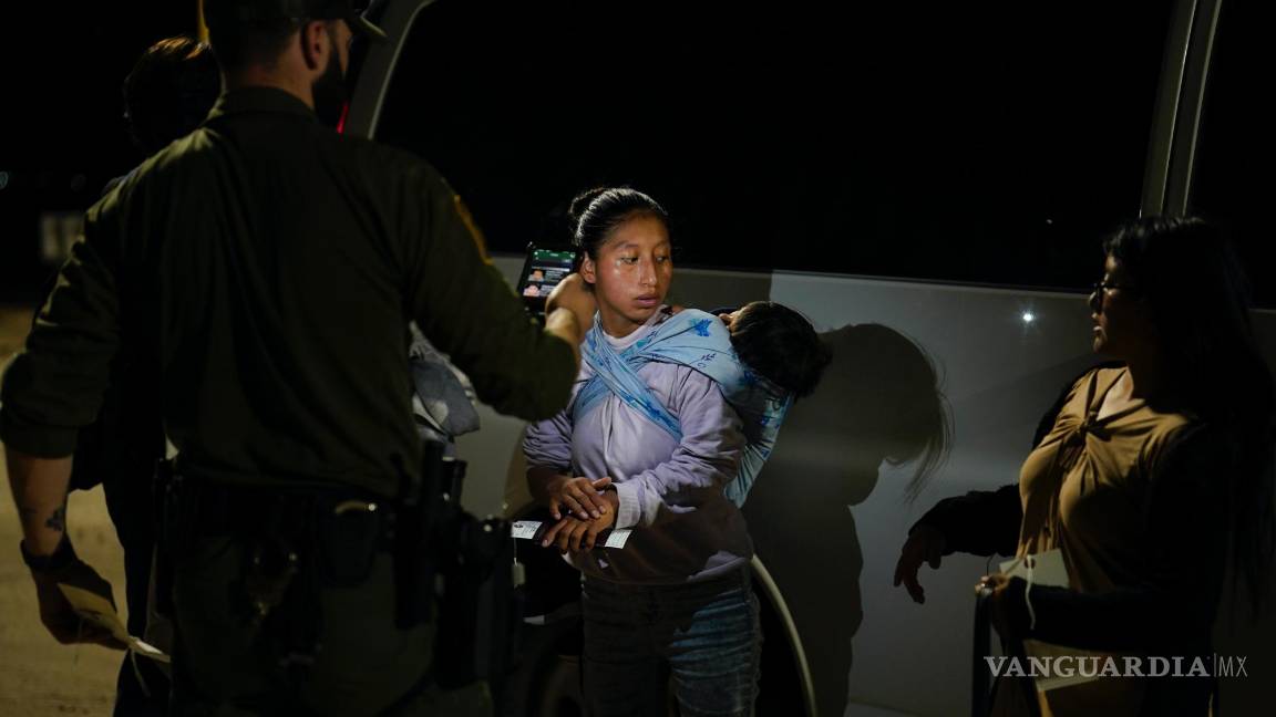 $!Una mujer de Ecuador responde las preguntas de un agente de la Patrulla Fronteriza mientras espera para solicitar asilo después de cruzar la frontera.