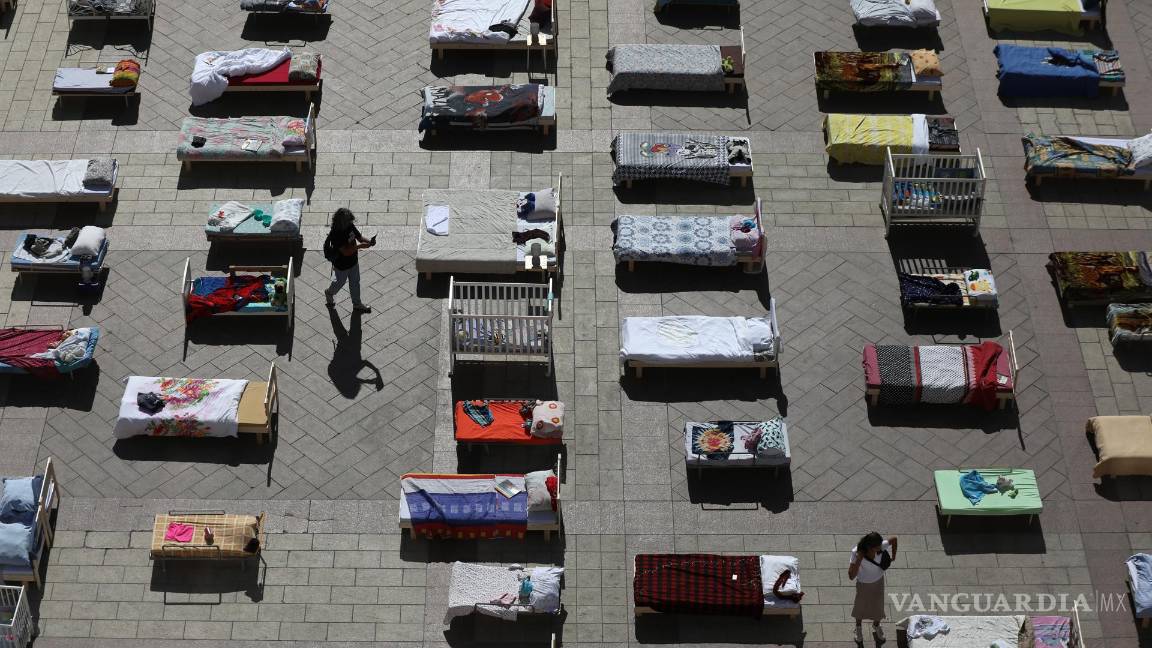 $!Personas mira algunas de las 230 camas vacías que representan a los rehenes retenidos por Hamás en Gaza en la Plaza del Municipio de Jerusalén.