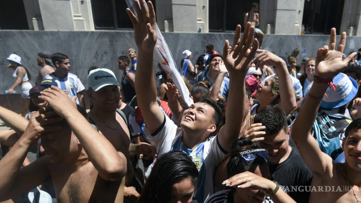 $!Fanáticos del fútbol miran hacia arriba pidiendo a los vecinos que echen agua en Buenos Aires, Argentina.