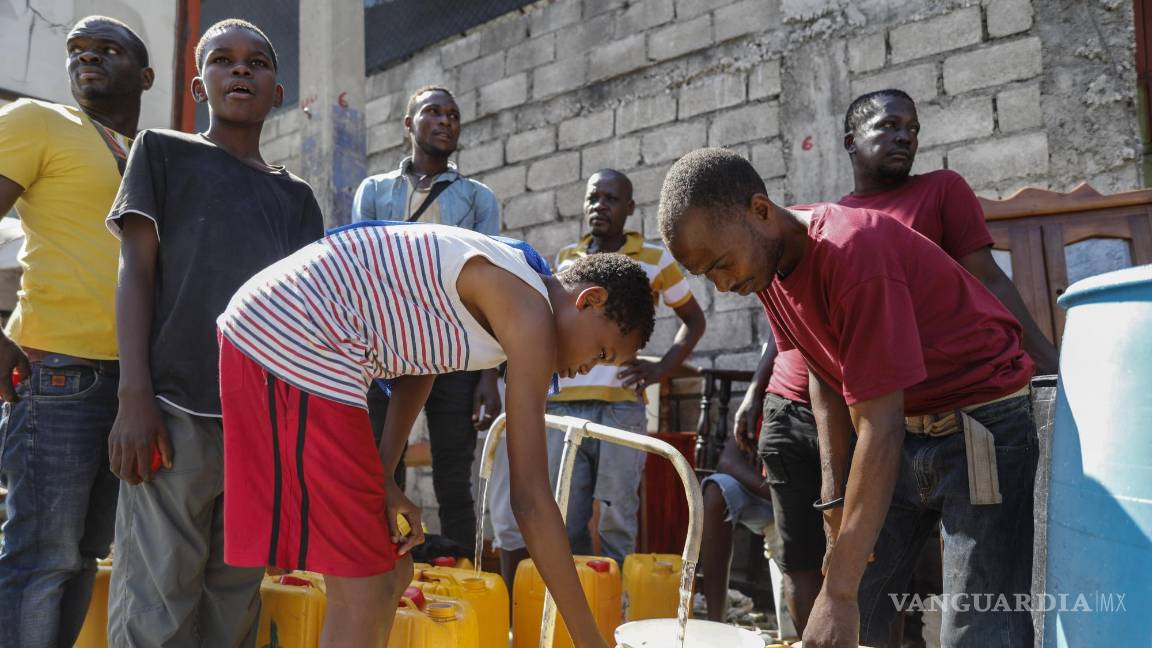 $!Residentes llenan garrafas con agua potable, en Puerto Príncipe, Haití, el 8 de marzo de 2024.